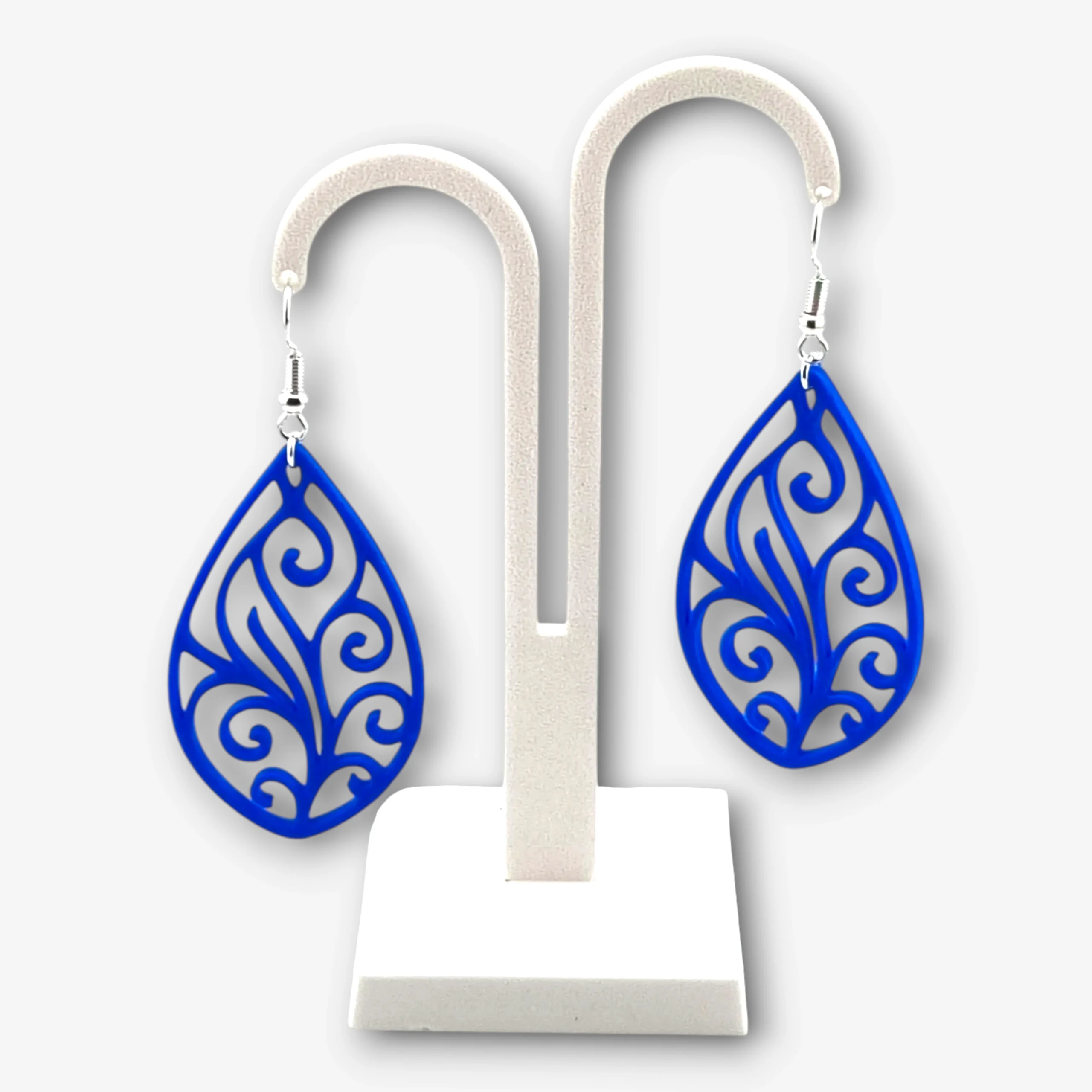 A pair of blue Paisley Filigree Teardrop earrings displayed on a stand.